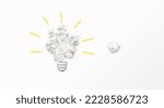 Small photo of Try to brainstorm harder for better idea innovation result concept, light bulb shape from paper balls on light background