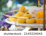 Small photo of Close up of 'Kanom Jamongkut' with other Thai Dessert on afternoon tea set tray, a kind of crown-like yellow sweetmeat mainly made of yolk and sugar.