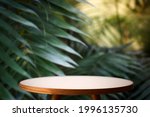 Small photo of Jungle table background. Interior table for a cosmetic item against the backdrop of tropical plants, palms and jungle.