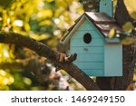Wooden blue birdhouse on a...