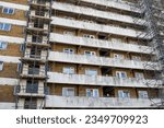 Small photo of Dirty and rundown residential apartment block in poor area of relative deprivation covered in scaffolding and undergoing renovation