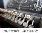 Small photo of An ornate vintage cash register, with narrow focus on the farthing key