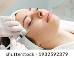Small photo of The doctor cosmetologist makes the rejuvenating facial injections procedure for tightening and smoothing wrinkles on the face skin of a beautiful, young woman in a beauty salon. Cosmetology, skincare