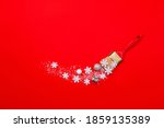 Christmas compositions.Creative layout made of white snowflakes, snow, Christmas tree and gift paint brush on red background. Flat lay, top view, copy space.
