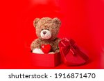 teddy bear hold heart  and present box  on red background valentine's day