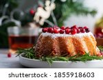 Horizontal close up winter Christmas cake with cranberries and rosemary at festive decor