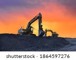 Small photo of Excavator working on earthmoving at open pit mining on amazing sunset background. Backhoe digs sand and gravel in quarry. Heavy construction equipment during excavation at construction site