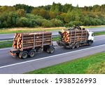 Timber truck transporting cut trees from forest along highway. Transport raw timber from felling site. Harvesters, forest machines and clearing of plantation in forests. Logging industry