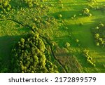 Small photo of Zigzag River in wild. Water supply. Small river in field and forest in swamp, Aerial view. Wildlife Refuge Wetland Restoration. Green Nature Scenery. River in Wildlife. Freshwater Lakes and Ecosystem.