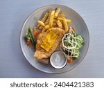 Small photo of Fish And Chips - Deep Fried Red Snapper Fillet In Crispy Batter, Served With Tar Tar Sauce. French Fries Or And Mixed Salad