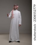 Small photo of A saudi character wearing thob standing carrying a car key on withe background.