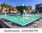 Small photo of Quarry fountain in Plaza de la Liberacion, square pond, spout with jets of water gushing, part of Degollado theater and buildings in background, historic center, sunny day, Guadalajara, Jalisco Mexico