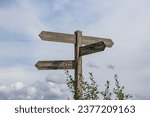 Small photo of Wooden signpost at crossroads in Gulpen-Wittem region against cloud-covered sky, towards towns: Epen, Hurpesch, Bommering and Mechelen, hiking trails, cloudy day in South Limburg, Netherlands