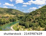 Small photo of Tandem of contemporary architecture and eternal green nature. Millau Viaduct and Tarn valley with its river. Aveyron, Occitania, France