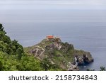 Small photo of Cantabrian Sea ceaselessly erodes rocky coast creating tunnels, arches, and caves on Gaztelugatxe island with 9th-century church on 80 meters above sea level top.Â Biscay, Basque Country