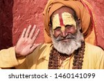Small photo of Sadhu man with traditional painted face in Pashupatinath Temple of Kathmandu, Nepal.Sadhu man refer to holy person.Nepal text in photo refer to prayer word om mani padme hum - Film grain effect