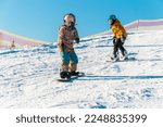 Small photo of Logoisk. Belarus. 01.09.2023. Two teenage snowboarders go down the slope of a snow-covered mountain in special gear. Snowboarding - descent at high speed on a special projectile - a snowboard.
