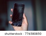Broken phone screen in hand
