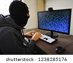 Small photo of Hacker trying to get somebody's password / Programmer with mask (thief) wants to hack your computer