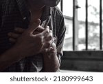 Small photo of Partial silhouette image of Asian elder man suffering from chest pain. Chest pain can be caused by heart attack, myocardial infarct or ischemia, myocarditis, pneumonia, oesophagitis, stress, etc.