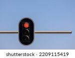Traffic light hanging on the pole with blue clear sky as background, Traffic signals or stop lights are signalling devices positioned at road intersections in order to control flows of traffic.