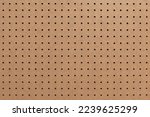 Small photo of Abstract background of brown perforated hardboard sheet, Plywood with pre-drilled with evenly spaced holes Nature seamless pattern texture, Surface and details of brown wood plank.