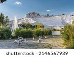 Small photo of Geese on the lake, calcified limestone terraces on background, Pamukkale in Turkey. Geese swim near the geothermal springs of Pamukkale, surrounded by travertines, white mountains in sunny weather.