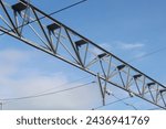 Small photo of Electric train trolley pole electrification system on railroad tracks with blue sky above