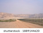 Desert Road Along A Metal Fence ...