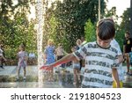 Small photo of Boys jumping in water fountains. Children playing with a city fountain on hot summer day. Happy friends having fun in fountain. Summer weather. Friendship, lifestyle and vacation.