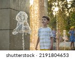 Small photo of Boy having fun in water fountains. Child playing with a city fountain on hot summer day. Happy kids having fun in fountain. Summer weather. Active leisure, lifestyle and vacation.