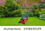 Small photo of Lawn mover on green grass in sunny day.