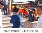 Small photo of Dibrugarh,Assam,India - January 22 2024 : Devotees Whispering wishes to ear of Lord Ganesha's vaahana the mouse named Mushak. It is said that the mouse transfers devotee wish or problem to lord Ganesh