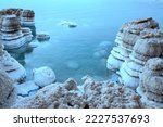 Salt pillars, Dead Sea coast. Beautiful bay with salt ledges. Sunrise, calm water. The concept of chopping the dead sea, nature, tranquility, travel, peaceful mood. Nobody. Sunrise.