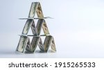 Small photo of 100 us dollar bills lined up in house of cards, money banner concept, financial pyramid, ponzi scheme, affaire, hustle, crook business