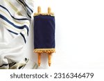 Small photo of Torah scroll with Tallit on a light background