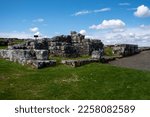 Blue, cloudy summer skies over ruins of Housesteads Roman Fort along the route of Hadrian's Wall, set amongst Northumberland countryside, UK