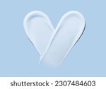 Heart shaped cosmetic smear of cream on a blue background