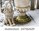 Small photo of Mass production polyresin lion covered with snow beside a flower bucket with patina Closeup of white planter in winter garden for book cover, brochure, flyer, magazine, CD cover design, website, app