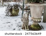 Small photo of Mass production polyresin lion covered with snow besides a flower bucket with patina, concrete planter in background. Closeup garden with snow for book cover, flyer, magazine, CD cover design, website