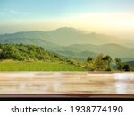 Small photo of Wooden table on blur mountain morning or evening view landscape, Warm feeling in orange or brown tones.