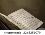 Small photo of Ancient open book manuscript (verses of Koran Book, Holy Islamic Text). XIII-th century arabic book pages. Selected focus, shallow depth. Copy space, grunge background. Istanbul, Turkey - Apr 19. 2022