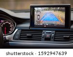 Small photo of Interior of premium car with rearview camera dynamic trajectory turning lines and parking assistant steering wheel turned right. Driver assistance parking system. Help assist options of luxury car.