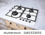 Small photo of Modern hob gas stove made of tempered white glass using natural gas or propane for cooking products on light countertop in kitchen interior.