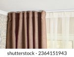 Small photo of Ceiling cornice with drapes white curtain or tulle. Interior details close up. White ceiling, plastic ceiling cornice with two rails brown matting fabric curtains and transparent curtains near window.