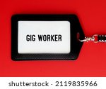 Small photo of ID card holder on red background with text GIG WORKER - someone who works in gig economy as independent contractor or freelancer, self-employed rather than employees