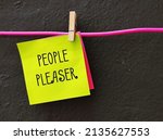 Small photo of Yellow note clipped with hanger wire with handwritten PEOPLE PLEASER, means one who overly concern with pleasing someone else, try hard to make other happy even go out of their way time or resources