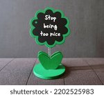 Small photo of Tree chalkboard with handwritten reminder STOP BEING TOO NICE, concept of stop being people pleaser, avoid trying to make everyone happy by being too nice