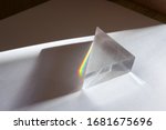 Rainbow spectrum of colors caused by breaking and dispersion of sunlight in a glass prism. Physics experiment.