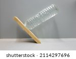 Small photo of Equilibrium situation where a horizontal bottle filled with water appears to fall but is in perfect balance because the center of gravity is above the fulcrum. Optical illusion, used in physics class.